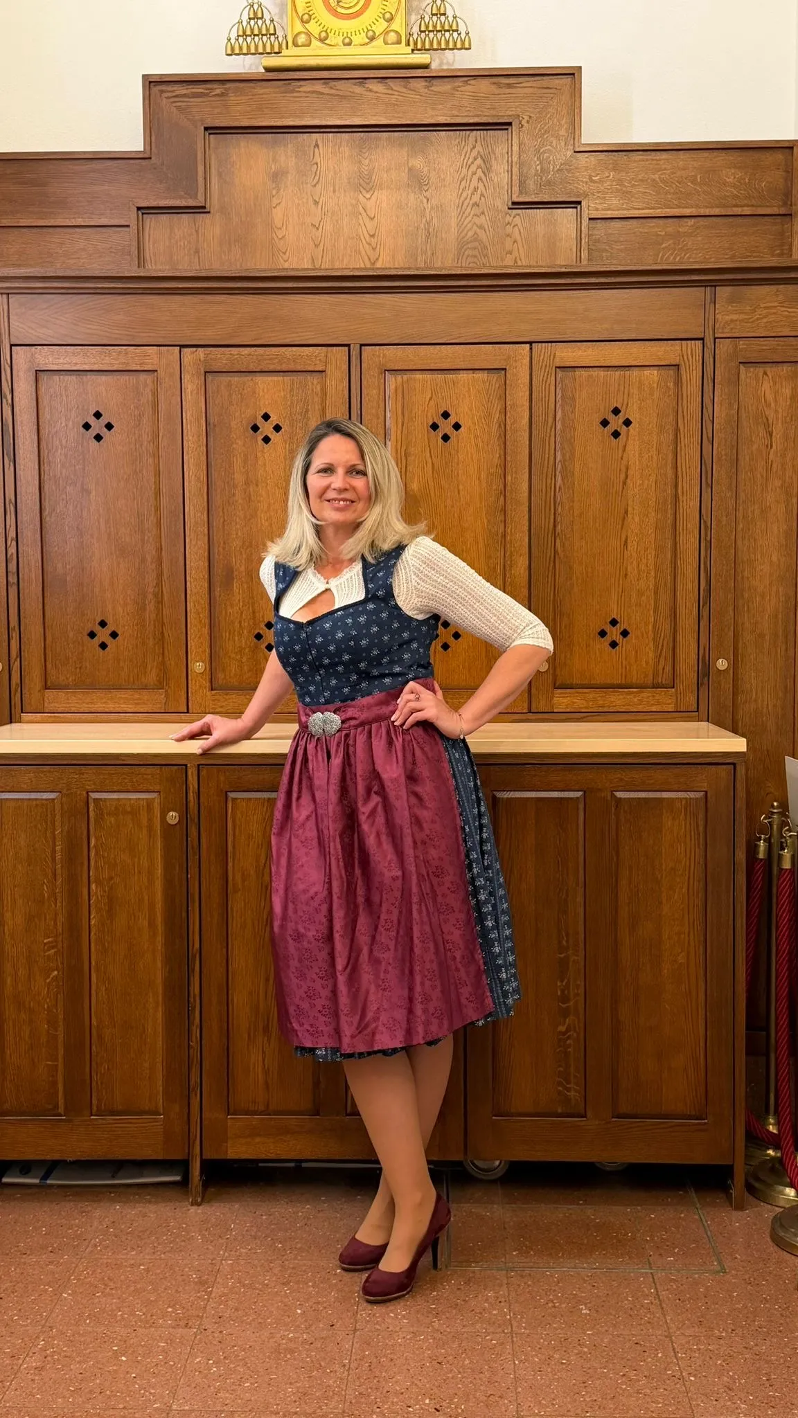 Jutta Reiseder im Innenraum, in blau-burgunderrotem Dirndl.